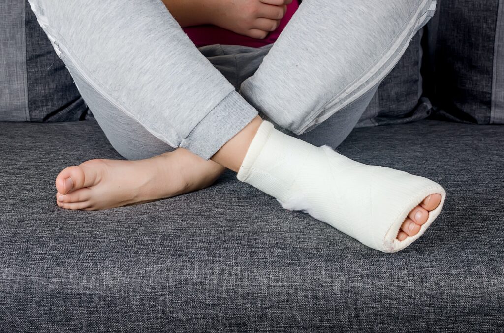 Person with a bandaged foot resting on a couch, representing wound care, ulcers, and limb preservation.