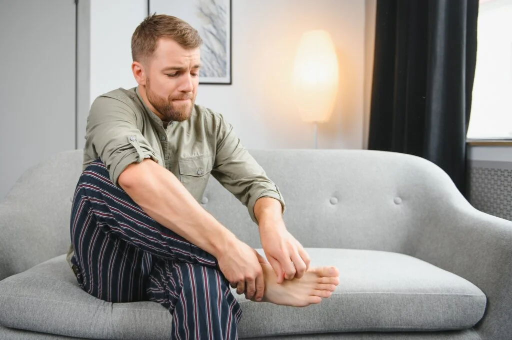 Man scratching his right foot
